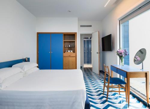 a hotel room with a bed and a desk and a table at Parco dei Principi in Sorrento