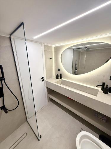 a bathroom with a mirror and a sink and a toilet at Acropolis Path - Elegant Apartment near Plaka in Athens
