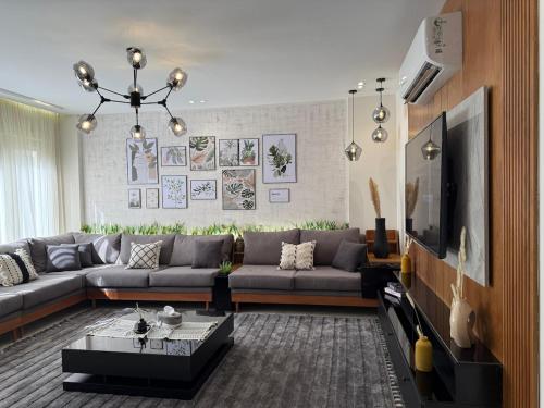 een woonkamer met een bank en een tv bij WS Luxury Apartment for Families with 5G Internet in Zes oktober (stad)