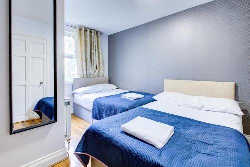 a small room with two beds and a mirror at West Hotel in London