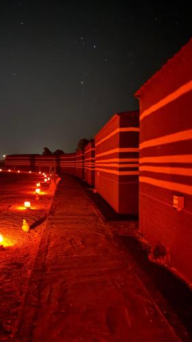 a row of candles sitting next to a wall at night at Wadi Rum Star Camp in Wadi Rum