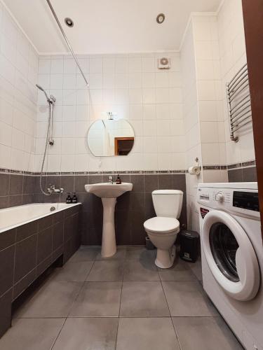 a bathroom with a toilet sink and a washing machine at Kyiv Sofia Apartment in Kyiv