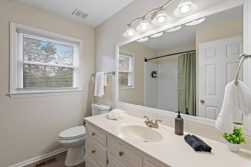 een badkamer met een wastafel, een toilet en een spiegel bij *New* Cozy / Near MTSU / Getaway ~ Sleeps 8+ in Murfreesboro
