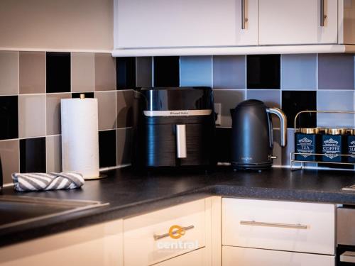 a kitchen counter with a coffeemaker and a coffee maker at CENTRAL SERVICED APARTMENTS - City Quay - 2 Bedrooms - En-Suite Bathroom - Dedicated Parking Space - Fully Equipped - Walk Away From Dundee Bus & Train Station - Close to City Centre with River Views and Balcony - NEW in Dundee