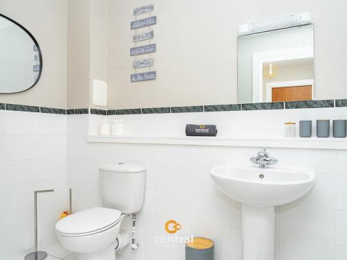 a white bathroom with a toilet and a sink at CENTRAL SERVICED APARTMENTS - City Quay - 2 Bedrooms - En-Suite Bathroom - Dedicated Parking Space - Fully Equipped - Walk Away From Dundee Bus & Train Station - Close to City Centre with River Views and Balcony - NEW in Dundee