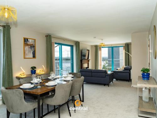 a dining room and living room with a table and chairs at CENTRAL SERVICED APARTMENTS - City Quay - 2 Bedrooms - En-Suite Bathroom - Dedicated Parking Space - Fully Equipped - Walk Away From Dundee Bus & Train Station - Close to City Centre with River Views and Balcony - NEW in Dundee