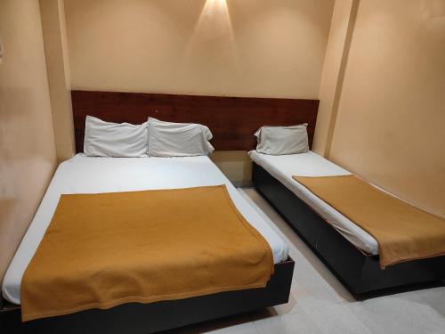 Una cama o camas en una habitación de TUKARAM HOTEL only 1 minute distance from Dwarkamai