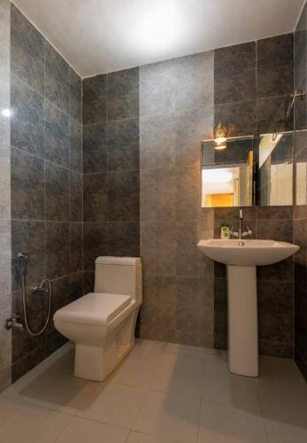 a bathroom with a toilet and a sink at Kasar Rainbow Yoga Retreat in Hawālbāgh