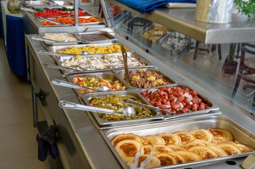 a buffet filled with different types of food in trays at Hotel Santa Cruz Huatulco in Santa Cruz Huatulco