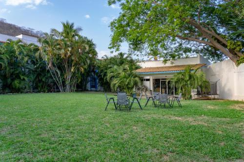 a group of chairs sitting in a yard at Hotel Santa Cruz Huatulco in Santa Cruz Huatulco