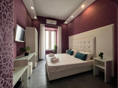 a bedroom with a large white bed and purple walls at Nereides Guest House in Naples