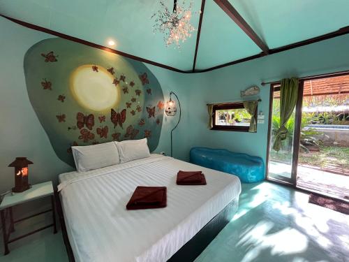 Un dormitorio con una cama con dos taburetes encima. en Green Wood Park Cottage Samui, Bangrak Beach, en Ban Nai Na