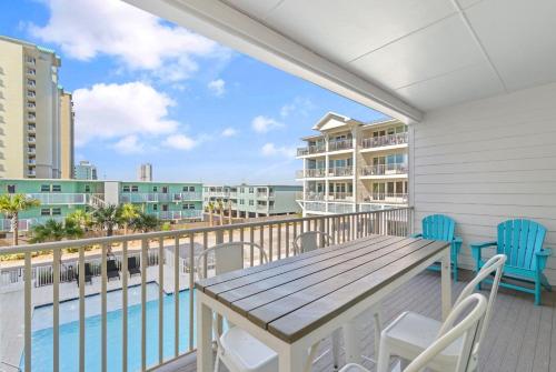 a balcony with a table and chairs and a pool at Sea Glass Unit 209 in Gulf Shores