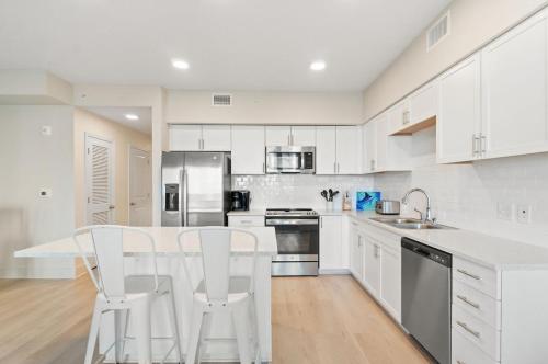 a kitchen with white cabinets and a table and chairs at Sea Glass Unit 209 in Gulf Shores