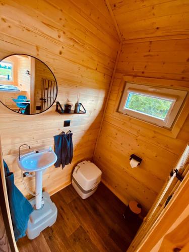 a bathroom in a log cabin with a sink and a mirror at Bull-Barn glamping in Liberec