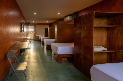 a room with a row of beds and shelves at Madre Tierra Hostal in Puerto Escondido