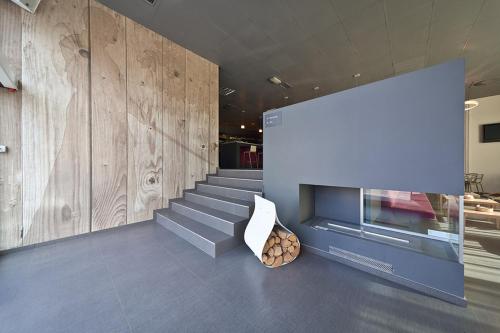 a lobby with a fireplace and stairs in a building at Bit Center Hotel in Ljubljana