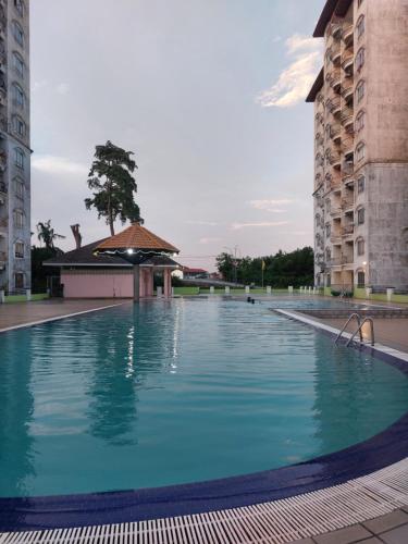 a large swimming pool between two tall buildings at Port Dickson Sunshine Resort in Port Dickson