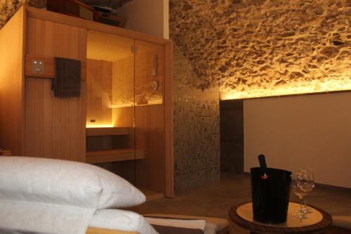 1 dormitorio con cama y mesa con copa de vino en Twinssuites - Adults only, en Tremosine Sul Garda