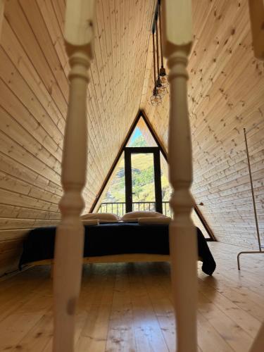 a bed in a room with a large window at Bato Cottages 