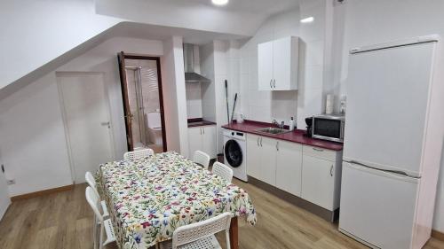 Una cocina con una mesa y sillas en una cocina. en Serranos Salamanca Centro, en Salamanca
