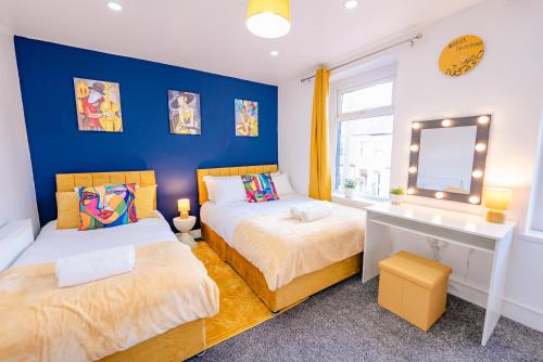 a bedroom with two beds and a desk and a mirror at Unique and Bright 6 Bedrooms Home Retreat - Fast WiFi - Close to Amenities in Cardiff
