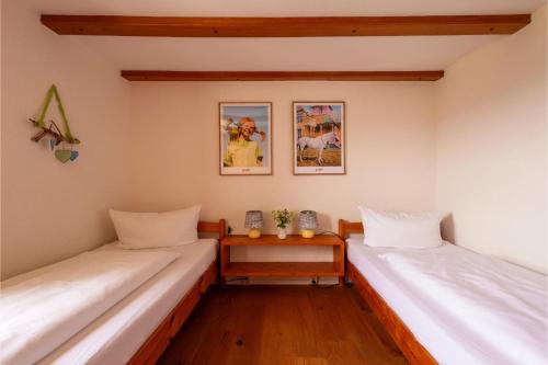 a room with two beds and a table in it at Ferienhof Sinz im Allgäu in Weiler-Simmerberg