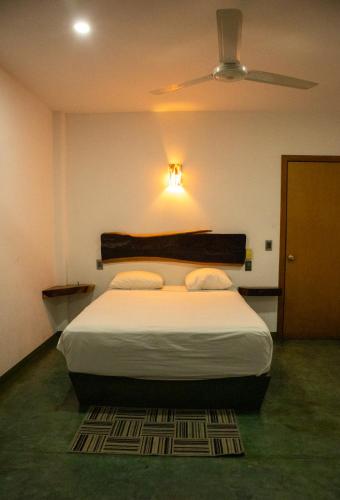 a bedroom with a large bed with a ceiling at Madre Tierra Hostal in Puerto Escondido