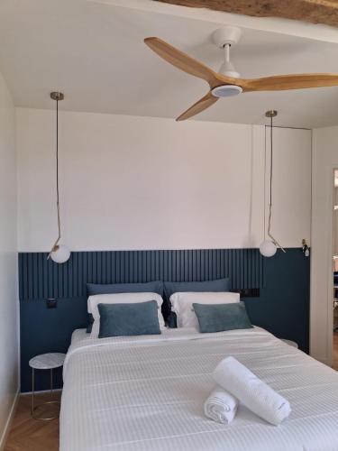 - un lit avec deux oreillers et un ventilateur de plafond dans l'établissement C'Châtelet, à Chartres