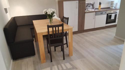 a kitchen with a table and chairs and a couch at Pension Fischerjung in Rostock