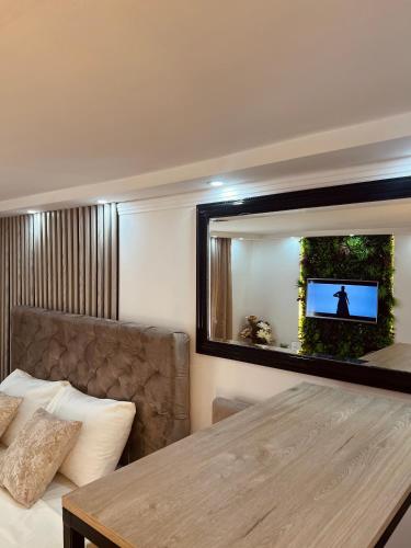 a living room with a table and a mirror at Apartman Podroom in Kraljevo