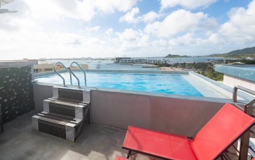 a swimming pool on a balcony with a red chair at 4 Bedroom Beachfront Condo with Private Pool D21 in Simpson Bay