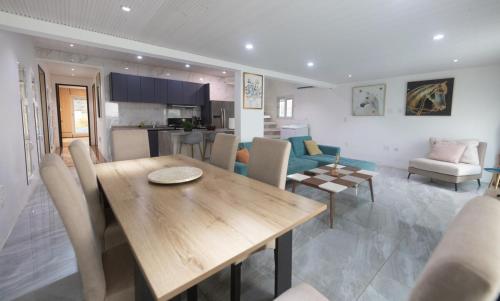 a kitchen and living room with a wooden table and chairs at 4 Bedroom Beachfront Condo with Private Pool D21 in Simpson Bay