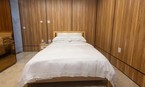 a large white bed in a room with wooden walls at 4 Bedroom Beachfront Condo with Private Pool D21 in Simpson Bay