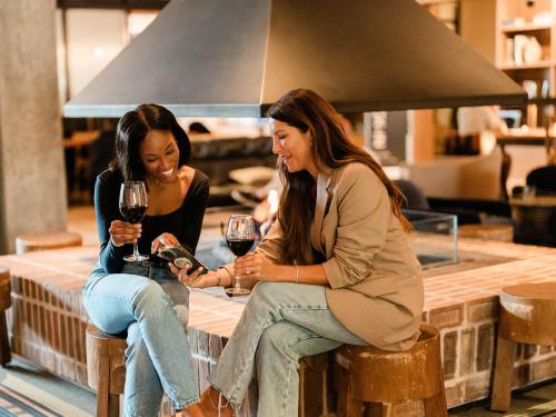 two women sitting at a bar drinking wine at The Junto Hotel in Columbus