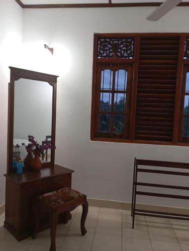 a room with a mirror and a table and a chair at Green Terrace Homestay 