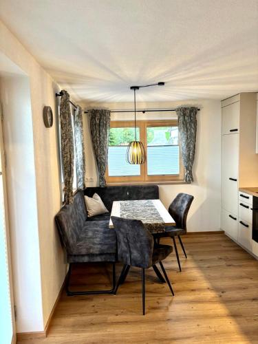 a dining room with a table and chairs and a window at Apart Anton in Hainzenberg