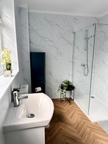 a white bathroom with a shower and a sink at House in Tyneside Perfect for Travelers, Groups & Contractors Free Parking in Hebburn-on-Tyne