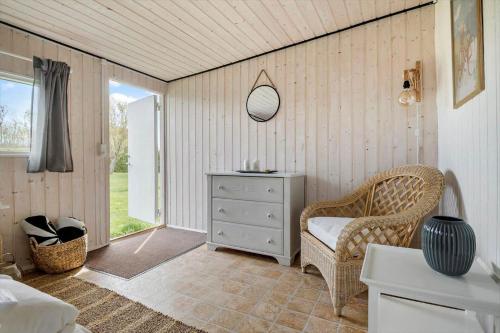 a bedroom with a chair and a dresser and a window at N319-Karrebaeksminde-Klintegardsvej-104 in Enø By