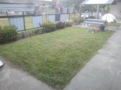 a yard with a bench and an umbrella in the rain at D'semporna Homestay in Semporna