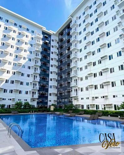 a large apartment building with a large swimming pool at Casa Vero, Resort-Style Condo for 4-6pax, 4 Pools in Manila