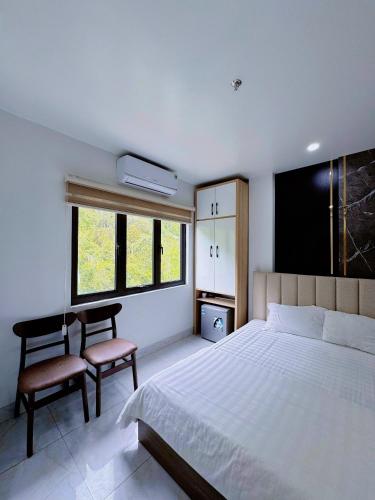 a bedroom with a bed and a desk and a chair at Lake View Hotel in Cat Ba