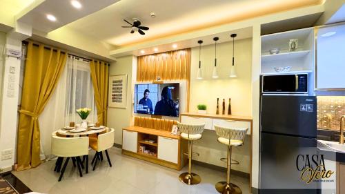 a kitchen with a table and a refrigerator at Casa Vero, Resort-Style Condo for 4-6pax, 4 Pools in Manila