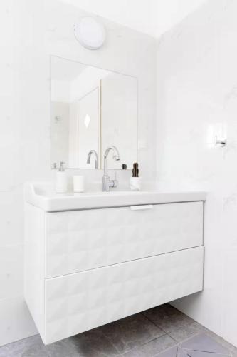 a white bathroom with a sink and a mirror at Sisso in the green north of Israel tivon Valley in Tiv‘on
