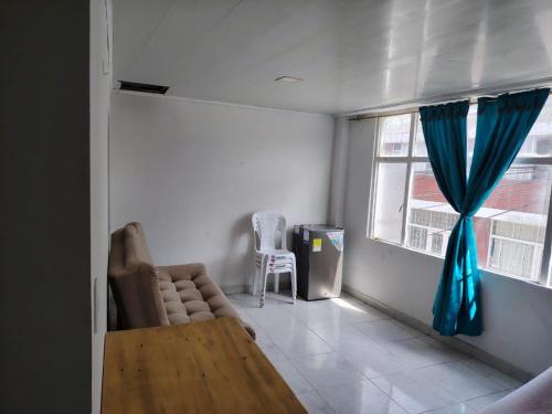 a living room with a couch and a table and a window at Encanto urbano in Moniquirá