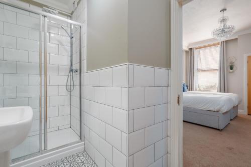 a white bathroom with a shower and a sink at Ocean Spray Suite by Grandeur Property in Bournemouth