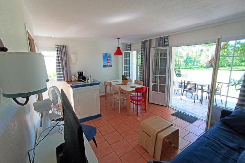 a kitchen and living room with a table and a kitchen and a dining room at Bright 50 M For 6 With Balcony And Garden in Moliets-et-Maa