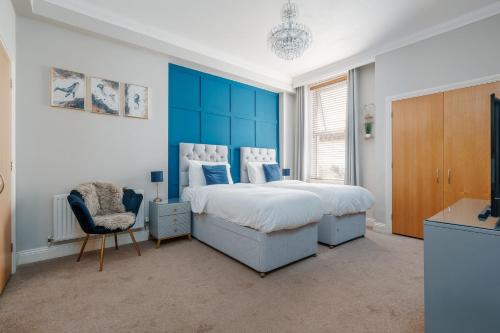 a bedroom with a large bed with a blue headboard at Ocean Spray Suite by Grandeur Property in Bournemouth