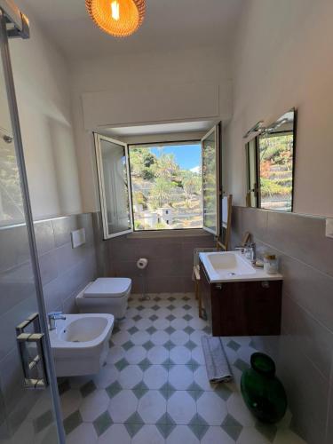 a bathroom with two sinks and a toilet and a window at Alba bordigotta in Bordighera
