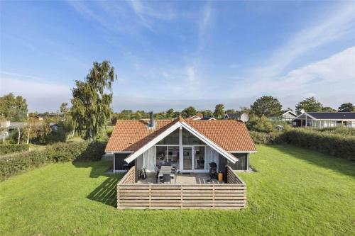 a small house with a deck in the grass at N102-Karrebaeksminde-Krageholmsvej-82 in Enø By